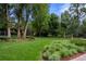 Spacious grassy backyard surrounded by mature trees and landscaping at 1700 E Tufts Ave, Cherry Hills Village, CO 80113