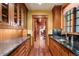 Butler's pantry with wood cabinets, granite countertops, and wood flooring at 1700 E Tufts Ave, Cherry Hills Village, CO 80113
