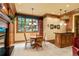 Dining area with a fireplace, a round table with four chairs, and a bar area under a window at 1700 E Tufts Ave, Cherry Hills Village, CO 80113