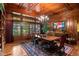 Formal dining room with wood paneled walls, coffered ceiling, and french doors to the outside at 1700 E Tufts Ave, Cherry Hills Village, CO 80113