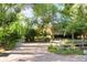 Long driveway with stone pavers, wooden fence, and mature landscaping at 1700 E Tufts Ave, Cherry Hills Village, CO 80113
