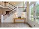Bright foyer featuring a grand staircase, elegant table with lamps, and a door leading to the outside at 1700 E Tufts Ave, Cherry Hills Village, CO 80113