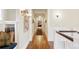 Hallway with hardwood floors, white trim, and sconce lighting at 1700 E Tufts Ave, Cherry Hills Village, CO 80113