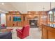 Cozy living room with wood paneling, fireplace, and built-in entertainment center and a plush red armchair at 1700 E Tufts Ave, Cherry Hills Village, CO 80113