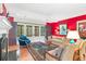 Stylish living room with fireplace, hardwood floors, bright red accent wall, and french doors at 1700 E Tufts Ave, Cherry Hills Village, CO 80113
