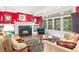 Cozy living room with a fireplace, bright red accent wall, and large doors leading to a balcony at 1700 E Tufts Ave, Cherry Hills Village, CO 80113