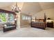 Spacious main bedroom with four-poster bed, large windows, and a seating area at 1700 E Tufts Ave, Cherry Hills Village, CO 80113