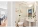 Stylish powder room with pedestal sink and decorative mirror reflecting the stairway and dining room at 5058 E Cherry Creek South Dr, Denver, CO 80246