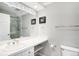 Bright bathroom has a long vanity with sink, shower, and modern fixtures at 5058 E Cherry Creek South Dr, Denver, CO 80246