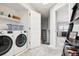 Bright laundry room with modern washer and dryer, convenient shelving, and easy access to the bedroom at 5058 E Cherry Creek South Dr, Denver, CO 80246