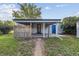 Backyard featuring a covered patio with privacy wall, grass, trees, and a chain link fence at 2105 S Irving St, Denver, CO 80219