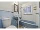 Full bathroom with blue fixtures including sink and bathtub with tiled walls and patterned floor at 2105 S Irving St, Denver, CO 80219