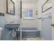 Full bathroom with blue fixtures including sink and bathtub with tiled walls and patterned floor at 2105 S Irving St, Denver, CO 80219