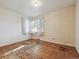 Bedroom with hardwood floors, single hung windows with white sheer curtains, and patterned wallpaper at 2105 S Irving St, Denver, CO 80219
