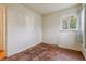 Bedroom with hardwood floors, single hung window with white sheer curtains, and white walls at 2105 S Irving St, Denver, CO 80219
