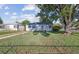 A cozy home with mature trees, a green lawn, and chain link fence at 2105 S Irving St, Denver, CO 80219