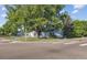 View of home with mature trees, green lawn, and chain link fence on a corner lot at 2105 S Irving St, Denver, CO 80219