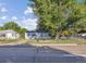View of home with mature tree, green lawn, and chain link fence at 2105 S Irving St, Denver, CO 80219