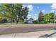 A cozy home featuring mature trees, a green lawn, and a chain link fence at 2105 S Irving St, Denver, CO 80219