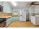 Eat-in kitchen features light green cabinets, wood countertop, gas range, white refrigerator, and laminate wood flooring at 2105 S Irving St, Denver, CO 80219
