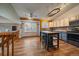 Bright kitchen featuring wood floors, an island with seating, and modern appliances at 11539 Depew Ct, Westminster, CO 80020