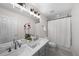 Bright bathroom with double sink vanity and a shower with white curtain at 2393 Yosemite St, Denver, CO 80238