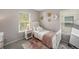 Charming bedroom with pink accents, soft rug, and large window providing natural light at 2393 Yosemite St, Denver, CO 80238