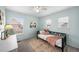 Cozy bedroom featuring soft blue walls, a daybed, and natural light from multiple windows at 2393 Yosemite St, Denver, CO 80238