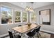 Dining room featuring large windows, modern chandelier, and rustic wood table at 2393 Yosemite St, Denver, CO 80238