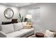 Relaxing living room with a comfortable couch, a round mirror, and soft natural light creating a peaceful atmosphere at 2393 Yosemite St, Denver, CO 80238