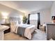 Bedroom with plush carpet, large window with curtains, and comfy chair near dresser at 10150 E Virginia Ave # 19-102, Denver, CO 80247