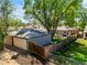 Aerial view of the backyard highlighting the garage, lush green lawn, mature trees, and wooden deck at 4456 S Washington St, Englewood, CO 80113