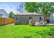 Inviting backyard showcasing a well-maintained lawn, a wooden fence, and cozy seating on the wooden deck at 4456 S Washington St, Englewood, CO 80113