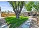 Grassy backyard featuring a large tree, outdoor seating, and a privacy fence at 4456 S Washington St, Englewood, CO 80113
