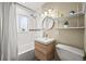 Bathroom features a modern vanity, subway tile walls, and a combined bathtub and shower with great lighting at 4456 S Washington St, Englewood, CO 80113