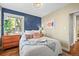 Comfortable bedroom featuring a large window, a blue accent wall, and decorative pillows on a neatly made bed at 4456 S Washington St, Englewood, CO 80113