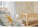 Charming Bedroom showcasing a comfortable chair with pillows and a view of the wooden crib at 4456 S Washington St, Englewood, CO 80113