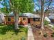 Charming brick home with a red front door, mature trees, and a well-manicured lawn at 4456 S Washington St, Englewood, CO 80113