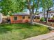 Well-maintained brick home featuring a lush front lawn and mature trees at 4456 S Washington St, Englewood, CO 80113