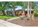 Brick home featuring a red door, well-kept lawn, and mature trees enhancing the property's curb appeal at 4456 S Washington St, Englewood, CO 80113