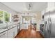 Bright kitchen with white cabinetry, stainless steel appliances and hardwood floors with an open layout at 4456 S Washington St, Englewood, CO 80113
