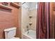 Tiled bath and shower space with built in shelving and a colorful curtain at 9532 W Walden Ave, Littleton, CO 80128