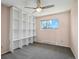 Bedroom with carpet, built-in shelving, a large window, and a ceiling fan at 9532 W Walden Ave, Littleton, CO 80128