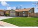 Charming brick home featuring a well-manicured lawn and attached garage in a residential neighborhood at 9532 W Walden Ave, Littleton, CO 80128