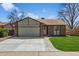 Inviting single-story home with a brick facade, attached garage, and a well-maintained front lawn at 9532 W Walden Ave, Littleton, CO 80128