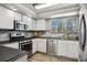Modern kitchen featuring stainless steel appliances, ample counter space, and stylish white cabinetry at 9532 W Walden Ave, Littleton, CO 80128