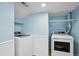 Functional laundry room with side-by-side washer and dryer and storage shelves at 9532 W Walden Ave, Littleton, CO 80128