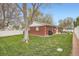 View of the fenced backyard featuring a manicured lawn, patio with seating, and mature trees at 9580 W 12Th Pl, Lakewood, CO 80215