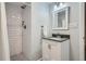 Bathroom featuring shower with white tile, vanity with dark countertop and sink at 9580 W 12Th Pl, Lakewood, CO 80215