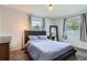Serene bedroom featuring plush carpet, neutral walls, a comfortable bed, and great natural light from two windows at 9580 W 12Th Pl, Lakewood, CO 80215
